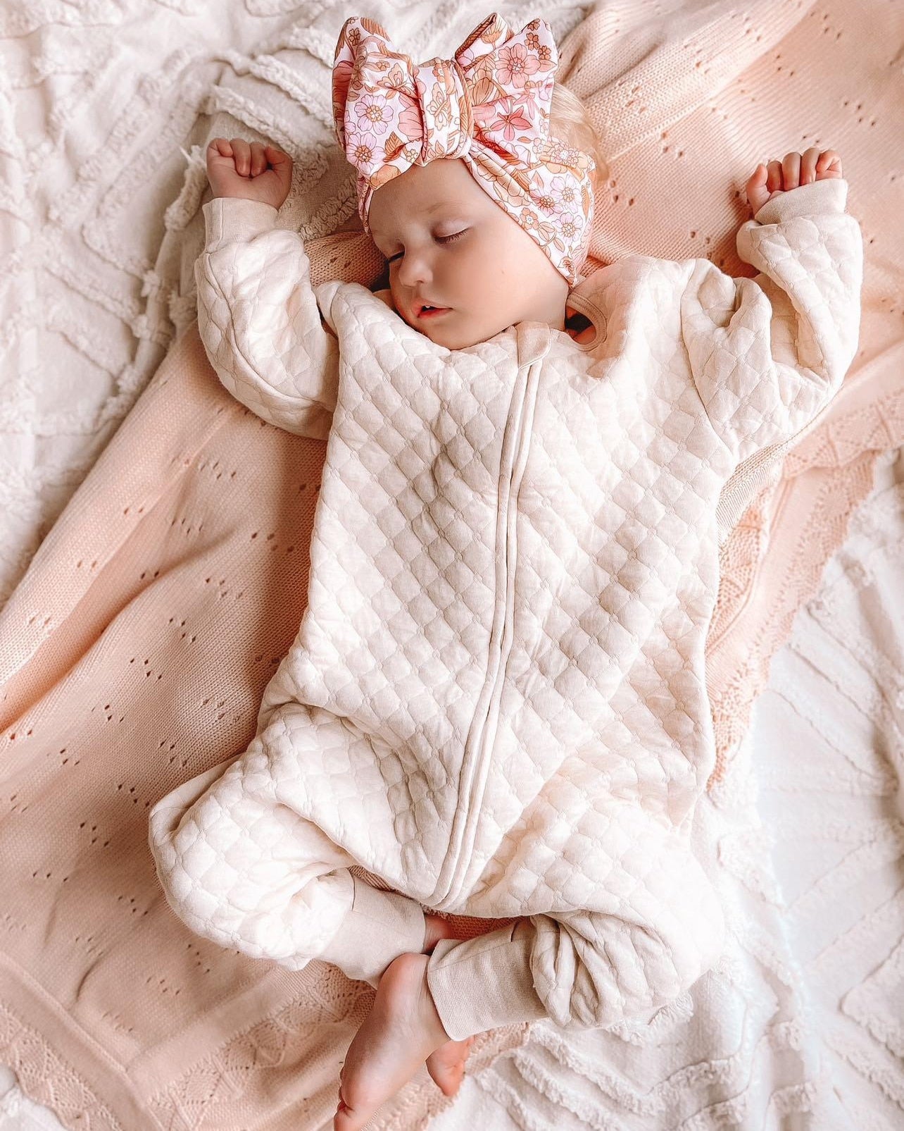 baby girl sleeping wearing a sleepsuit