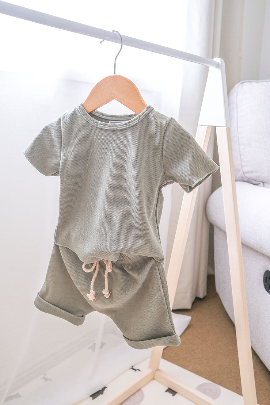 Baby green clothing set on a hanger