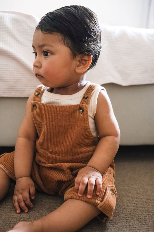baby wearing corduroy overalls
