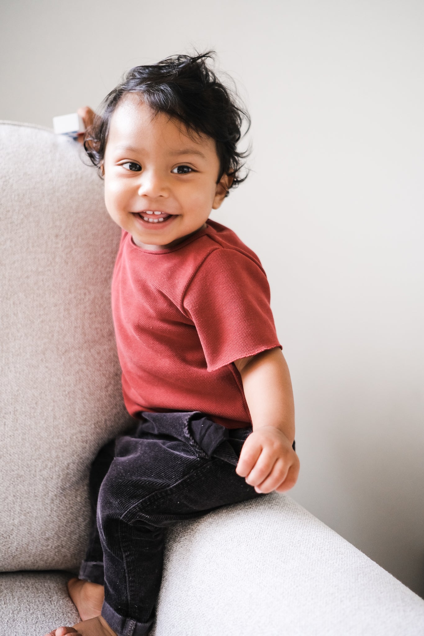 Baby boy wearing maroon set sitting on chair