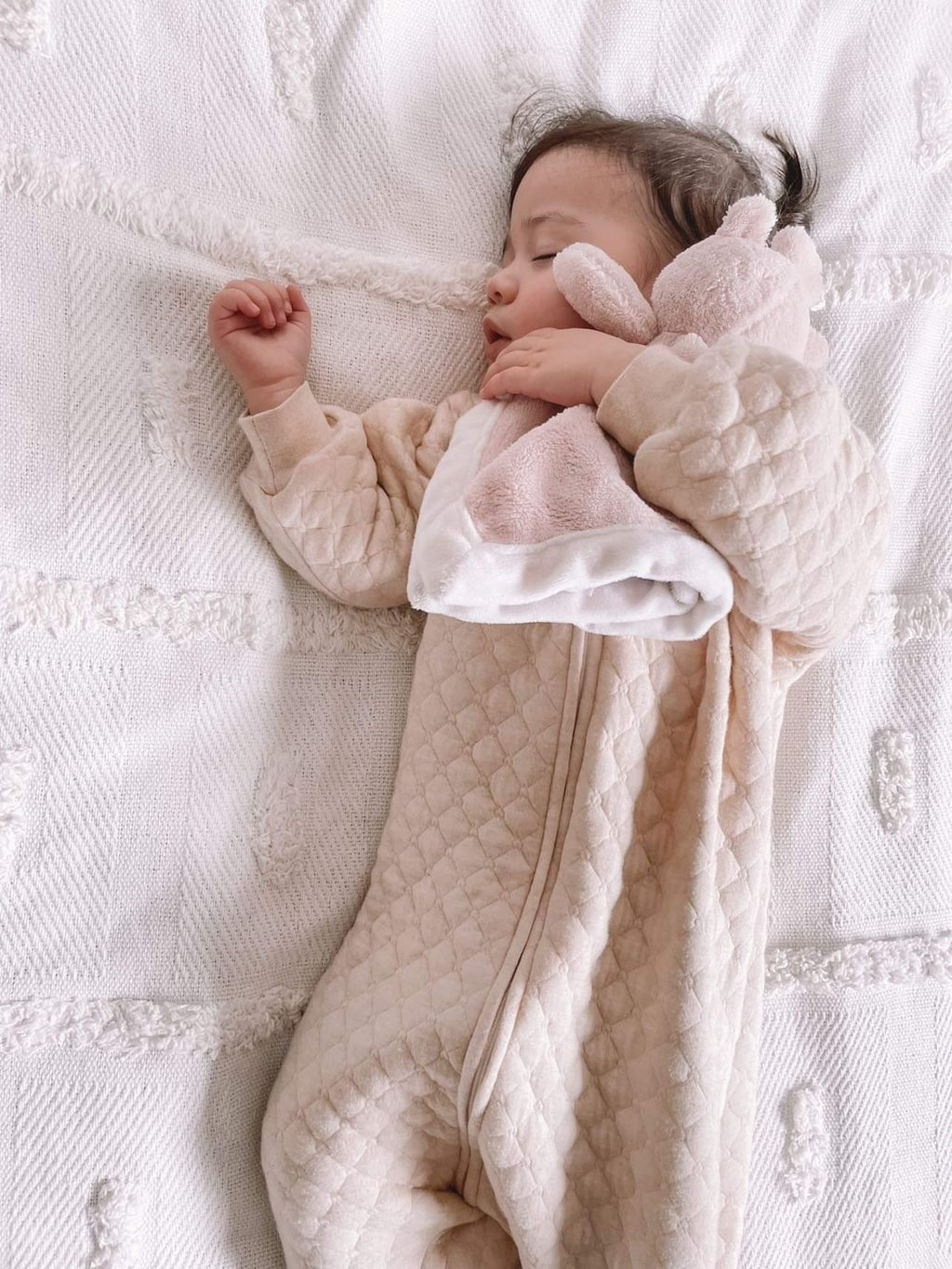 baby girl sleeping wearing a 1.0 tog sleep suit