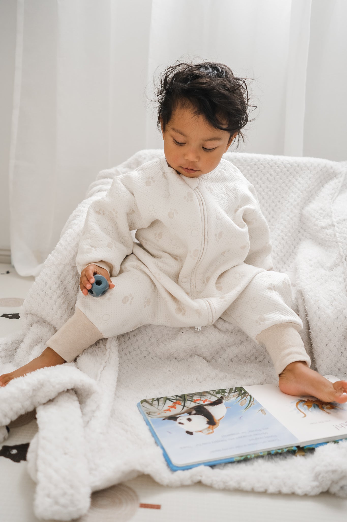 Toddler wearing Sleepsuit with a panda book