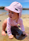 baby girl wearing pink sun hat with flap