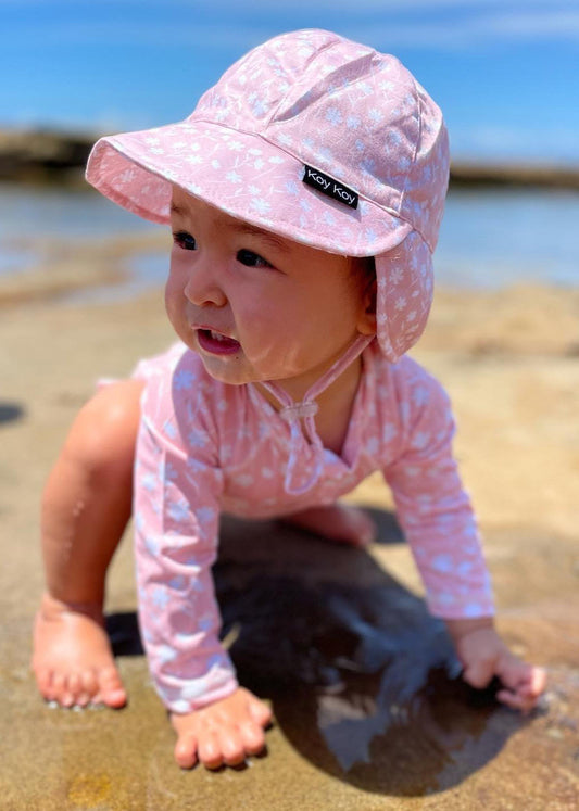 baby girl wearing pink sun hat with flap